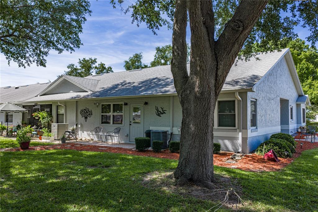 A single-story house with a gray stucco exterior, a shingled roof, and a grassy backyard — 6380 EGRET DRIVE UNIT 6, LAKELAND, FL
