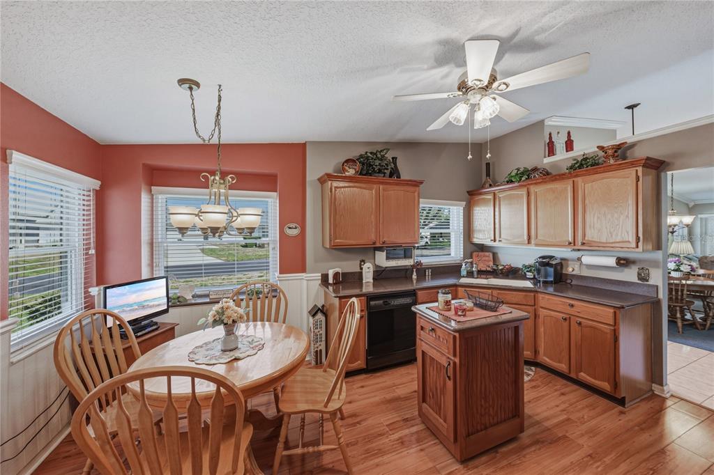 A kitchen and dining area with wood cabinets, a center island, and a round table — 6380 EGRET DRIVE UNIT 6, LAKELAND, FL