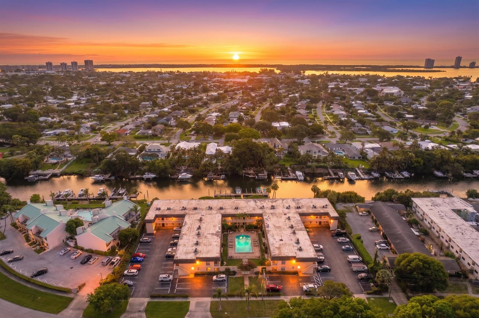 An aerial view shows a multi-story apartment complex with a central pool at sunset — 342 Southwind Drive # 118, North Palm Beach FL 33408, NORTH PALM BEACH, FL