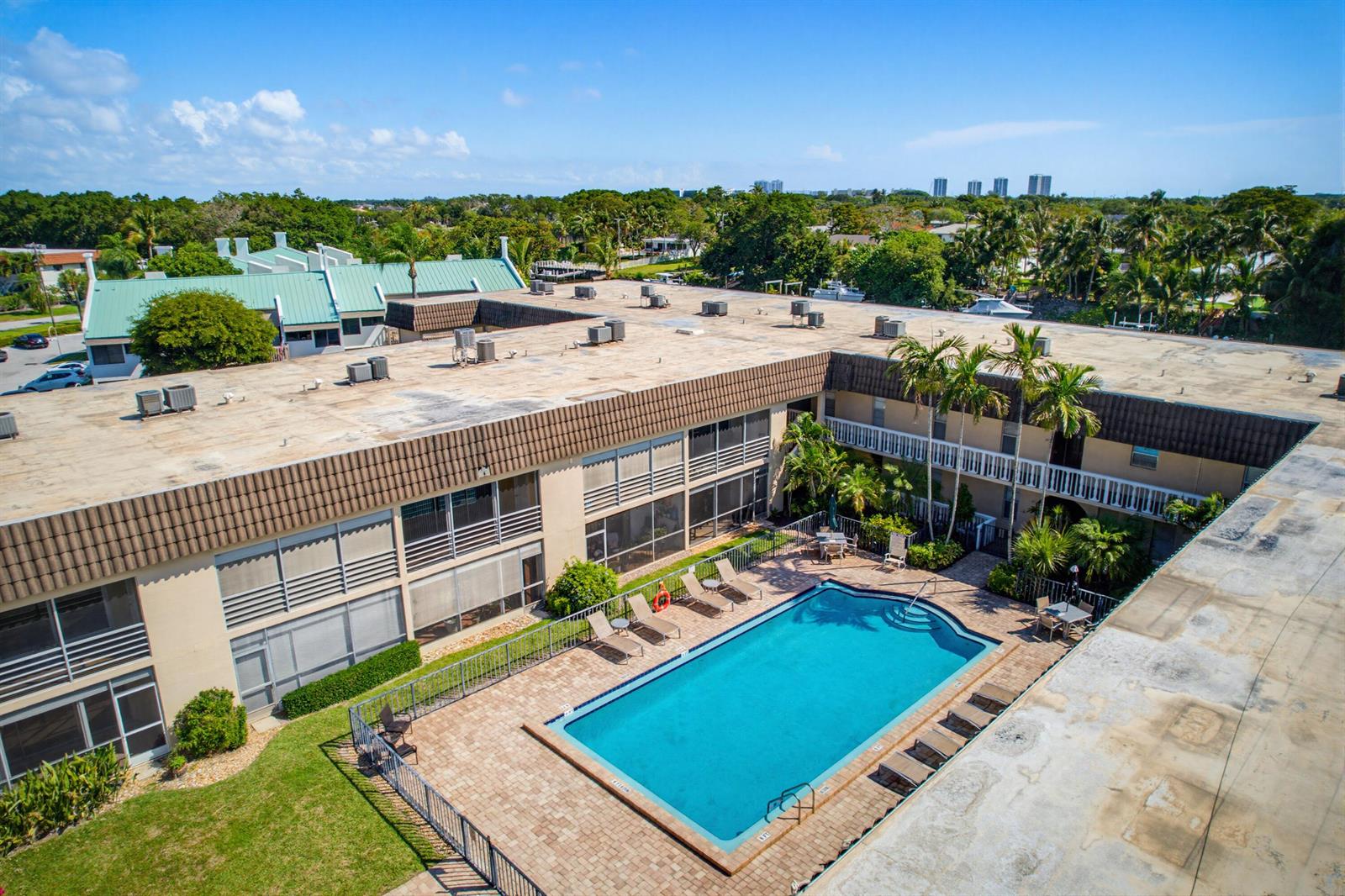 An aerial view shows a multi-story apartment building with a central swimming pool and courtyard — 342 Southwind Drive # 118, North Palm Beach FL 33408, NORTH PALM BEACH, FL