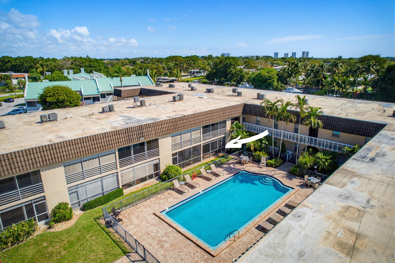 An aerial view of a rectangular apartment complex courtyard featuring a swimming pool and patio — 342 Southwind Drive # 118, North Palm Beach FL 33408, NORTH PALM BEACH, FL