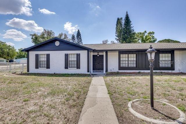 A single-story house with a white stucco facade, dark trim, and a front walkway — 920 LAKEVIEW DRIVE, WIMAUMA, FL