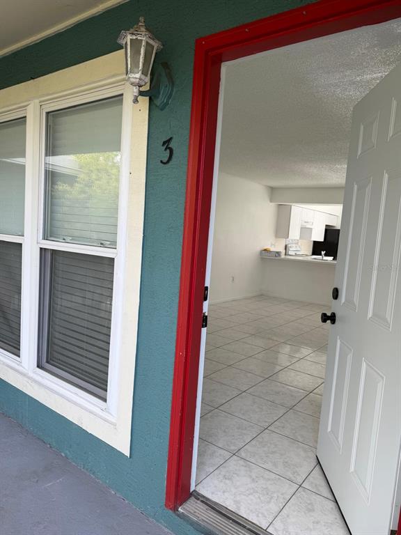 An open door reveals a tiled living area and kitchen with white cabinets — 1854 CARALEE BOULEVARD UNIT 3, ORLANDO, FL