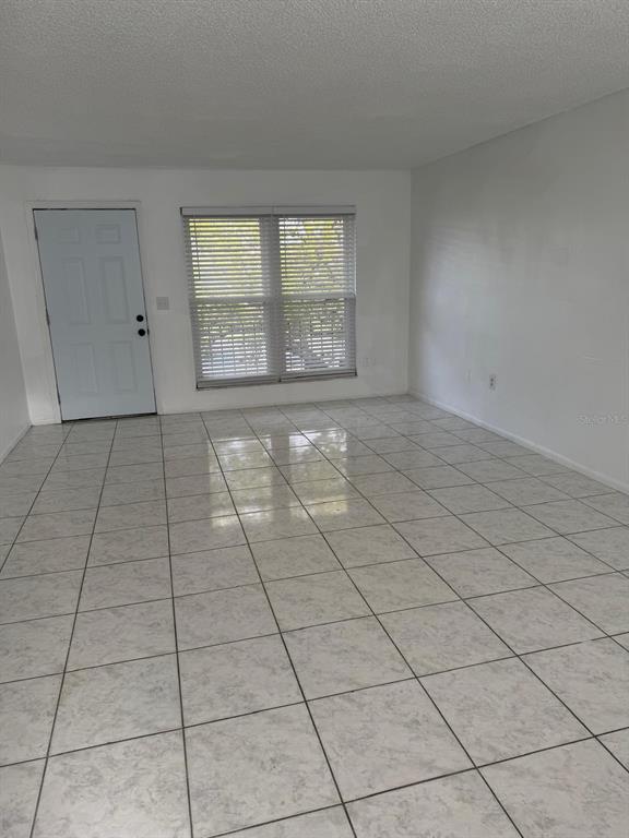 An empty room with white walls, a white door, and light-colored tiled flooring — 1854 CARALEE BOULEVARD UNIT 3, ORLANDO, FL