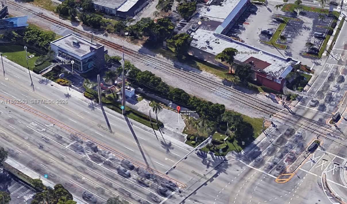 This aerial view shows a vacant lot situated between a multi-lane road and railroad tracks — 18560 Biscayne Blvd, Aventura FL 33180, AVENTURA, FL