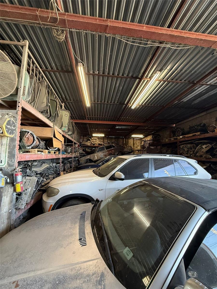 A cluttered indoor automotive salvage yard features stacked car parts and several parked vehicles — 12755 Cairo Ln, Opa-Locka FL 33054, OPA-LOCKA, FL