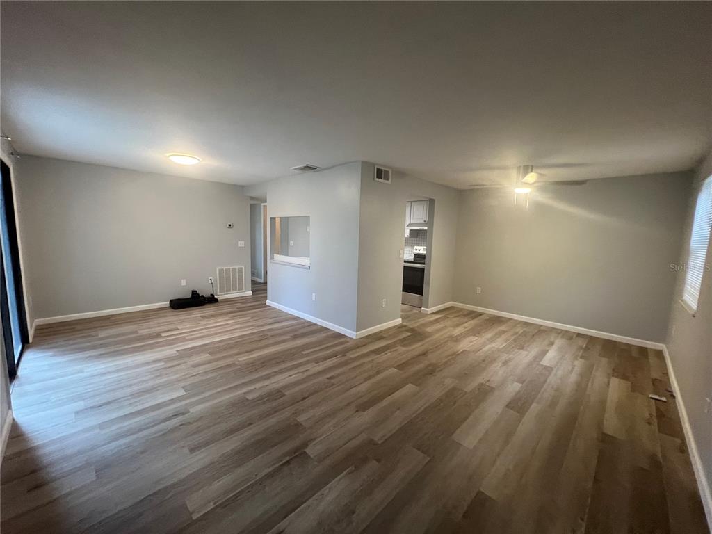 An open-concept living area features light gray walls and wood-look vinyl plank flooring — 4022 BEAVER LN NE UNIT 800 C, PORT CHARLOTTE, FL