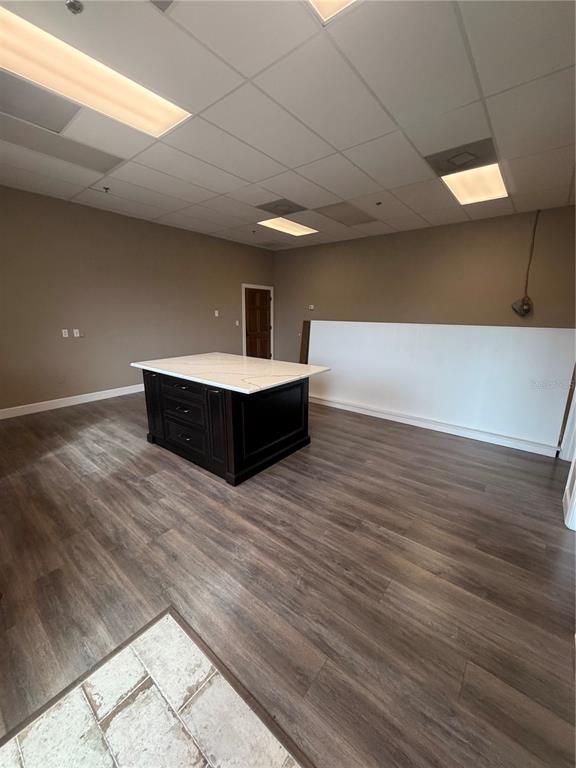 An interior room features a dark wood kitchen island with a white countertop and wood-look flooring — 910 BELLE AVENUE UNIT 1140, WINTER SPRINGS, FL