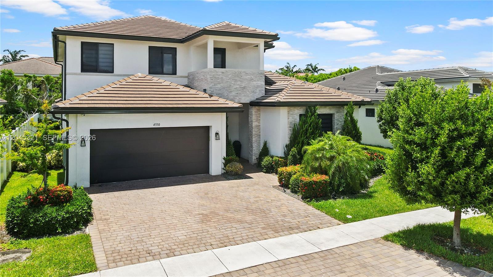 A two-story house with a brown tile roof, stone accents, and a paved driveway — 4550 SW 178th Ave, Miramar FL 33029, MIRAMAR, FL