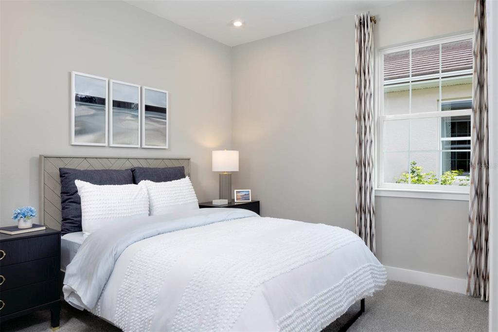 A bedroom features a bed with white bedding, a gray headboard, and two dark nightstands — 12128 MEDITATION TRAIL, VENICE, FL