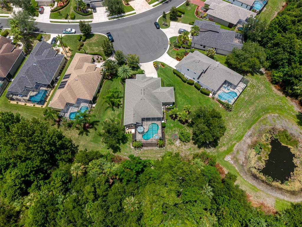 An aerial view shows several suburban houses with swimming pools near a wooded area — 12344 LAVENDER LOOP, BRADENTON, FL