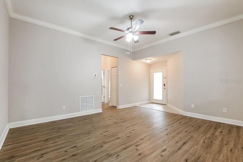 An empty room with light gray walls, wood-look flooring, and a ceiling fan — 348 ASHTON WOODS LANE, LEESBURG, FL