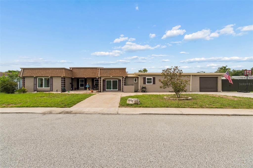 A concrete patio features outdoor seating, a fire pit, and heaters against a house exterior — 4306 NEWBURY DRIVE, NEW PORT RICHEY, FL