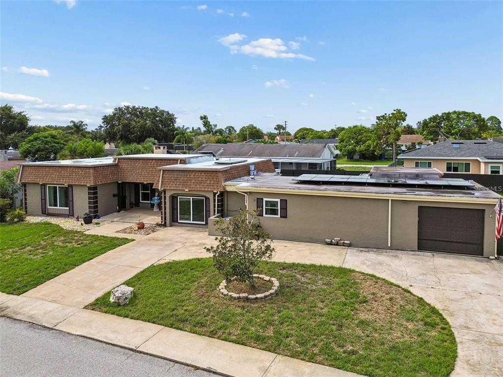 A single-story house with a brown mansard roof, a concrete driveway, and a front lawn — 4306 NEWBURY DRIVE, NEW PORT RICHEY, FL