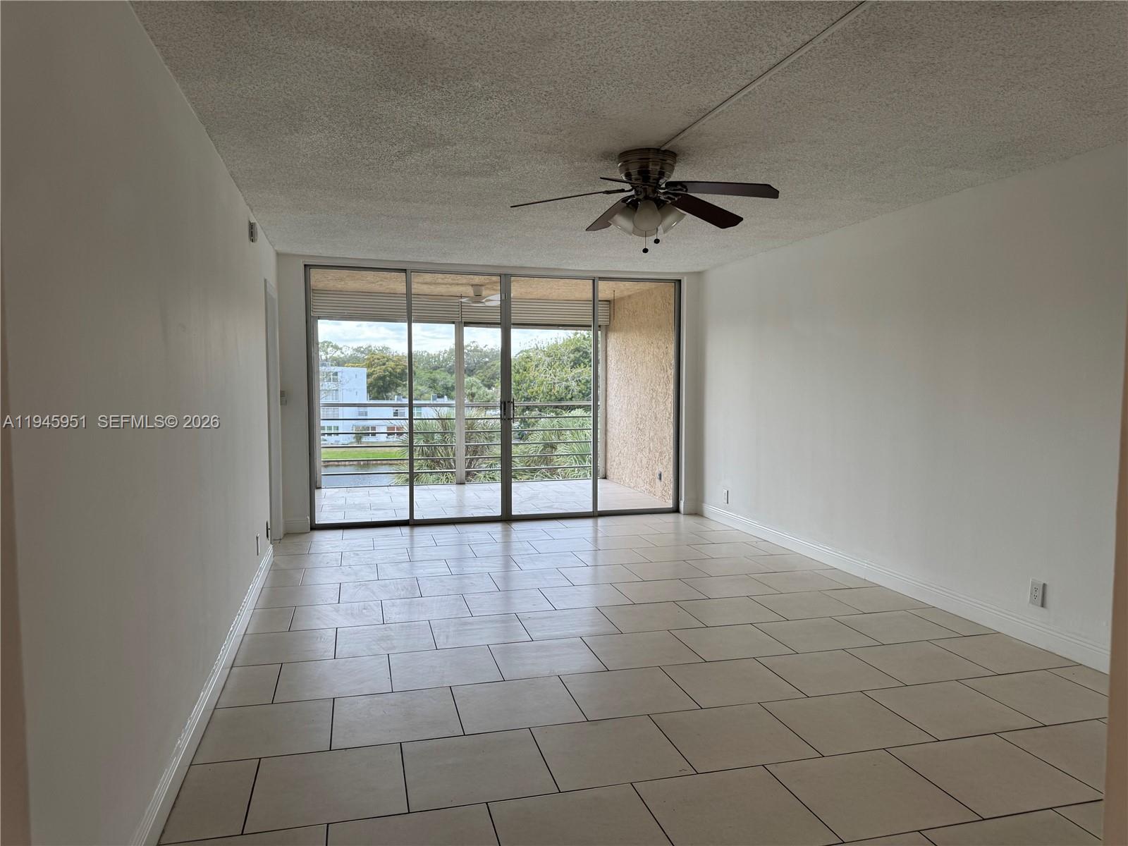 An empty room with white walls, tile flooring, a ceiling fan, and a sliding glass door — 1831 Sabal Palm Dr # 403, Davie FL 33324, DAVIE, FL