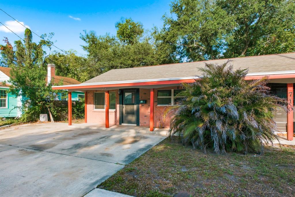 A single-story brick duplex with a covered concrete porch and a large palm tree — 708 PENNSYLVANIA AVENUE, CLEARWATER, FL