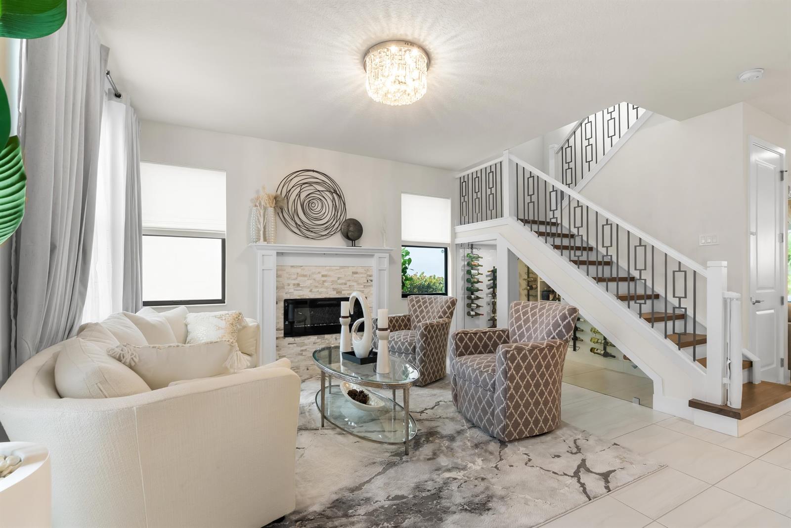 A living room features a fireplace, two patterned armchairs, a sofa, and a staircase — 7241 Stella Lane, Lake Worth FL 33463, LAKE WORTH, FL