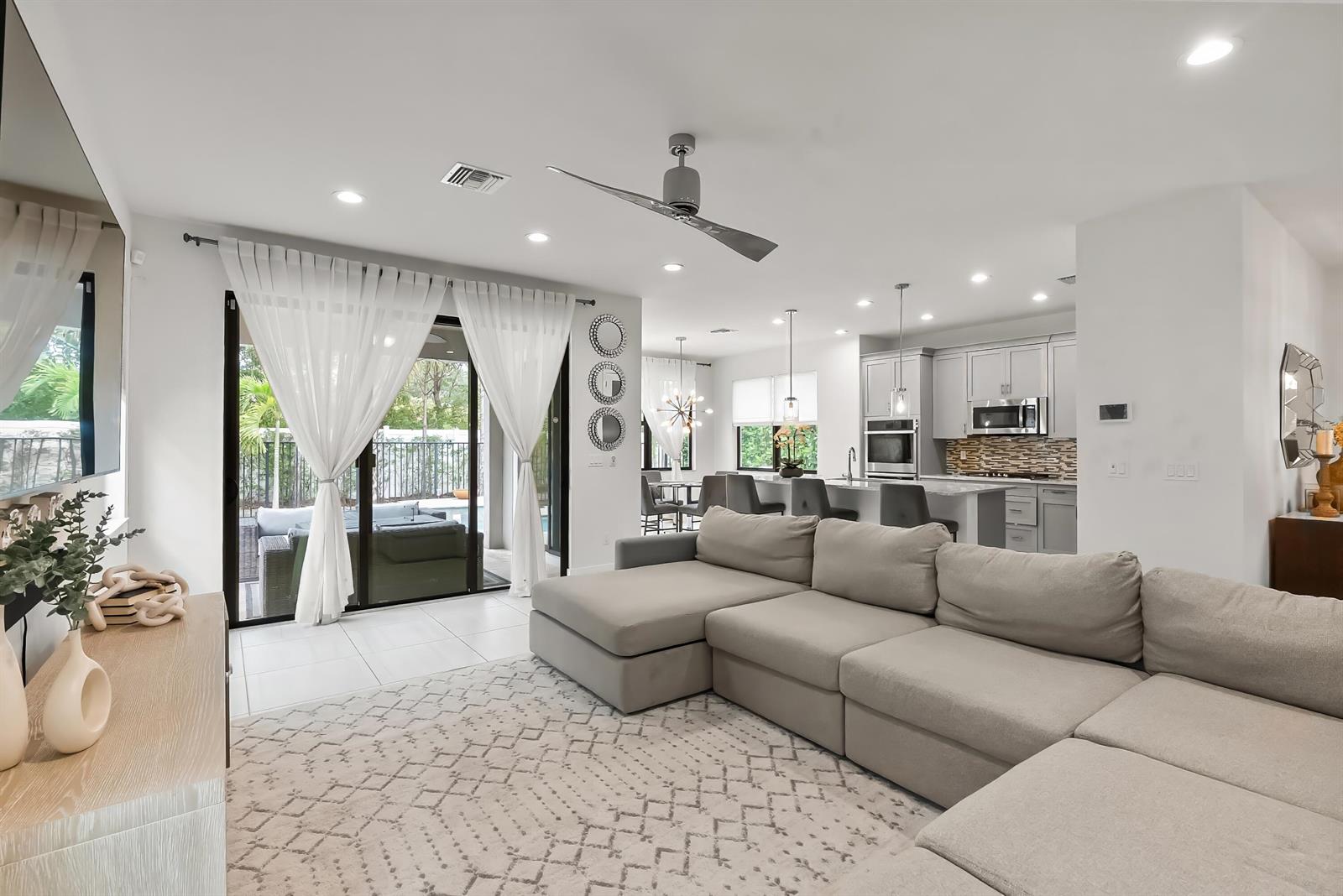 A living room with a sectional sofa opens to a patio through sliding glass doors — 7241 Stella Lane, Lake Worth FL 33463, LAKE WORTH, FL