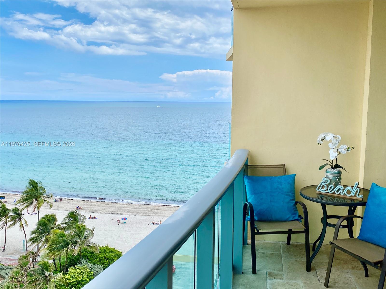 A balcony with outdoor furniture overlooks a sandy beach and the ocean — 2501 S Ocean Dr # 1104, Hollywood FL 33019, HOLLYWOOD, FL