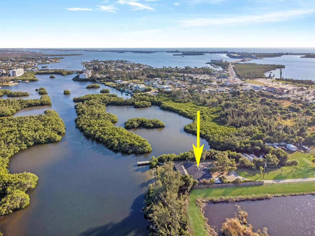 A wooden dock extends into a calm waterway surrounded by dense green mangrove trees — 300 E BAY HEIGHTS AVENUE, ENGLEWOOD, FL