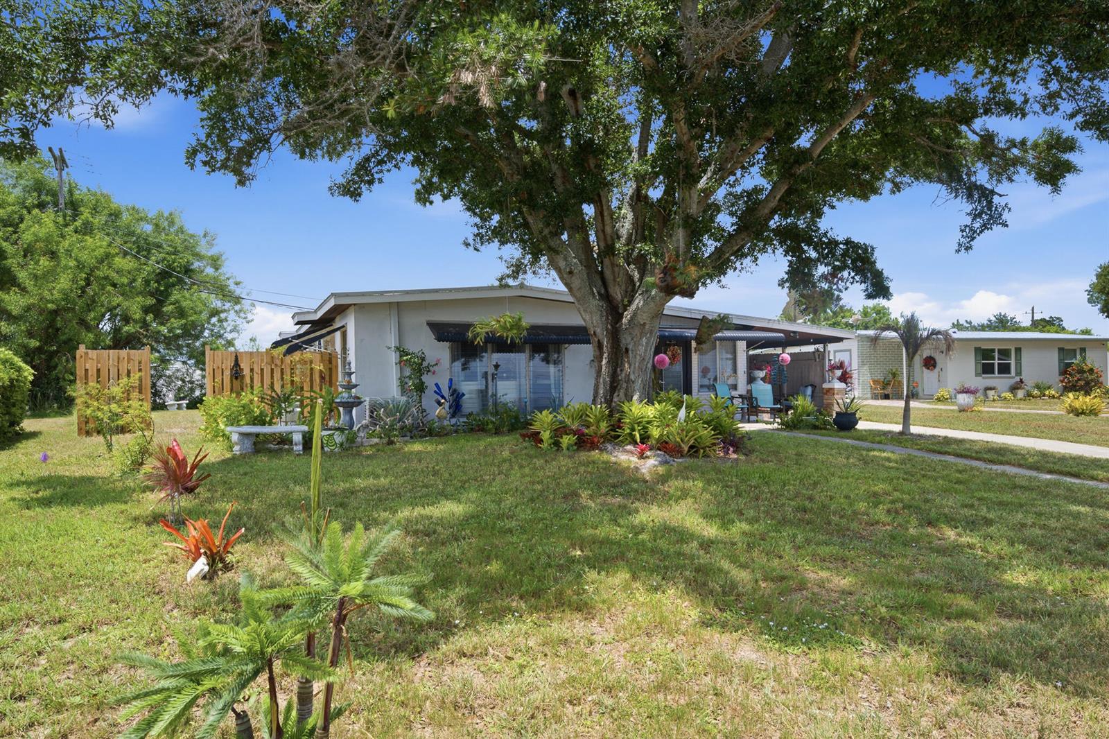 A single-story house with a large tree in the front yard and a lawn — 54 20th Lane SW, Vero Beach FL 32962, VERO BEACH, FL