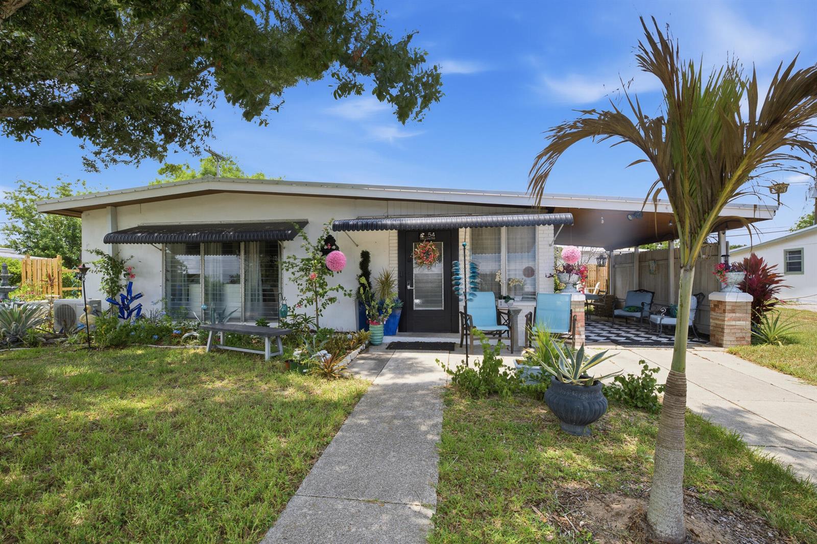 A single-story house with a white exterior, a front walkway, and a covered carport — 54 20th Lane SW, Vero Beach FL 32962, VERO BEACH, FL
