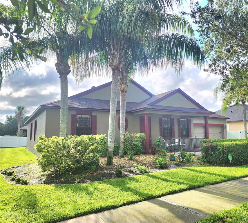 A single-story house with a brown exterior, red shutters, and palm trees in the front yard — 4061 ASHEVILLE LANE, ST CLOUD, FL