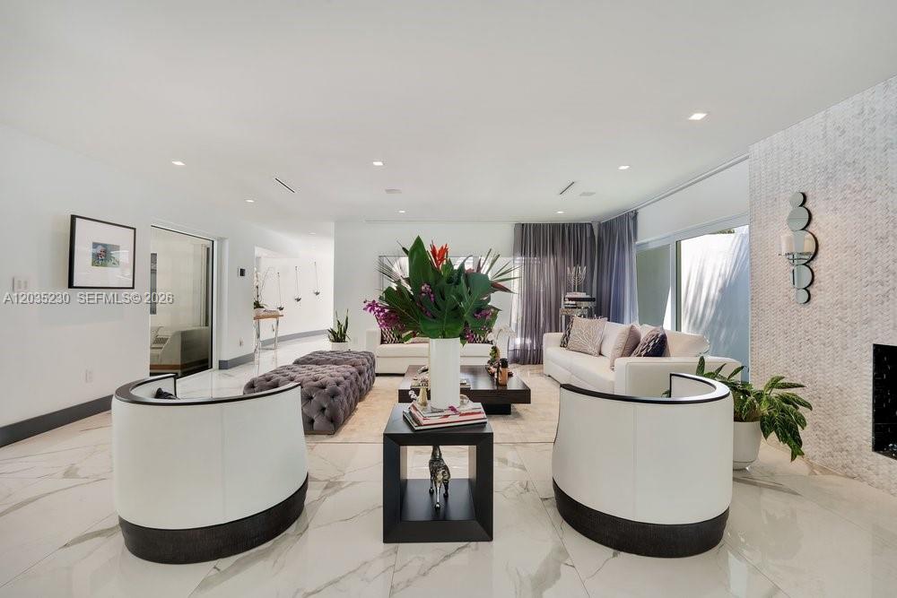 A modern living room features white marble floors, two curved chairs, and a white sofa — 6460 SW 133rd Dr, Pinecrest FL 33156, PINECREST, FL
