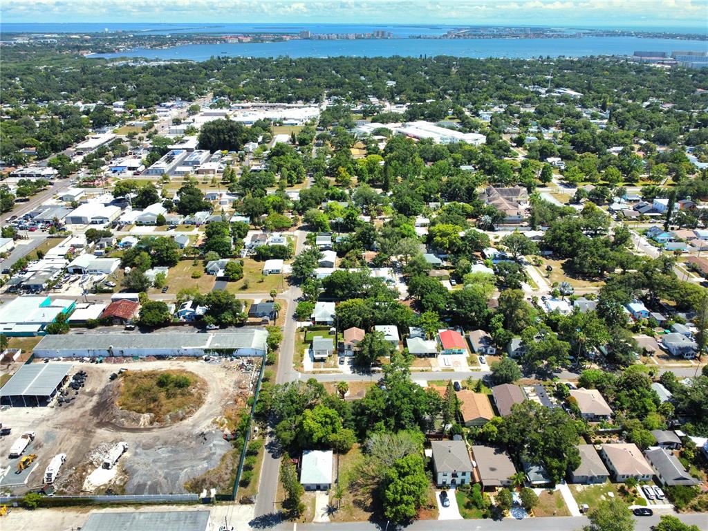 An aerial view shows a residential neighborhood with trees, houses, and a vacant lot — 5106 16TH AVENUE S, GULFPORT, FL