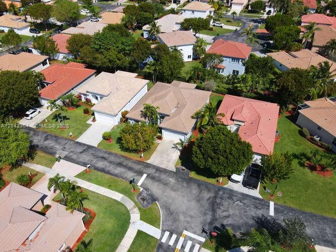 An aerial view shows a suburban neighborhood with several houses featuring tiled roofs and driveways — 2405 SE 5th Ct, Homestead FL 33033, HOMESTEAD, FL