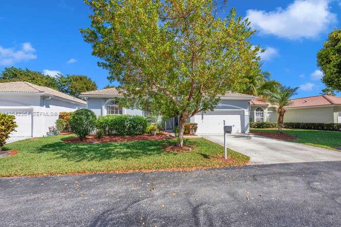 A single-story house with a driveway, a large tree, and a manicured lawn — 2405 SE 5th Ct, Homestead FL 33033, HOMESTEAD, FL