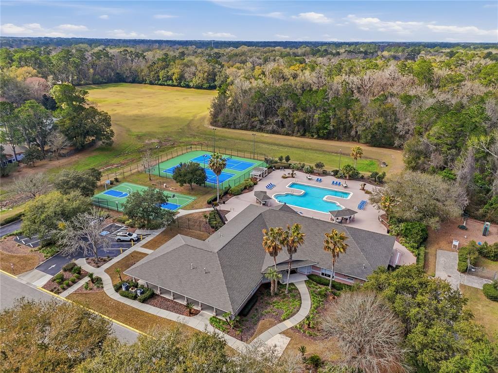 An aerial view shows a community clubhouse with a pool, tennis courts, and parking area — 4430 NW 35TH TERRACE, GAINESVILLE, FL