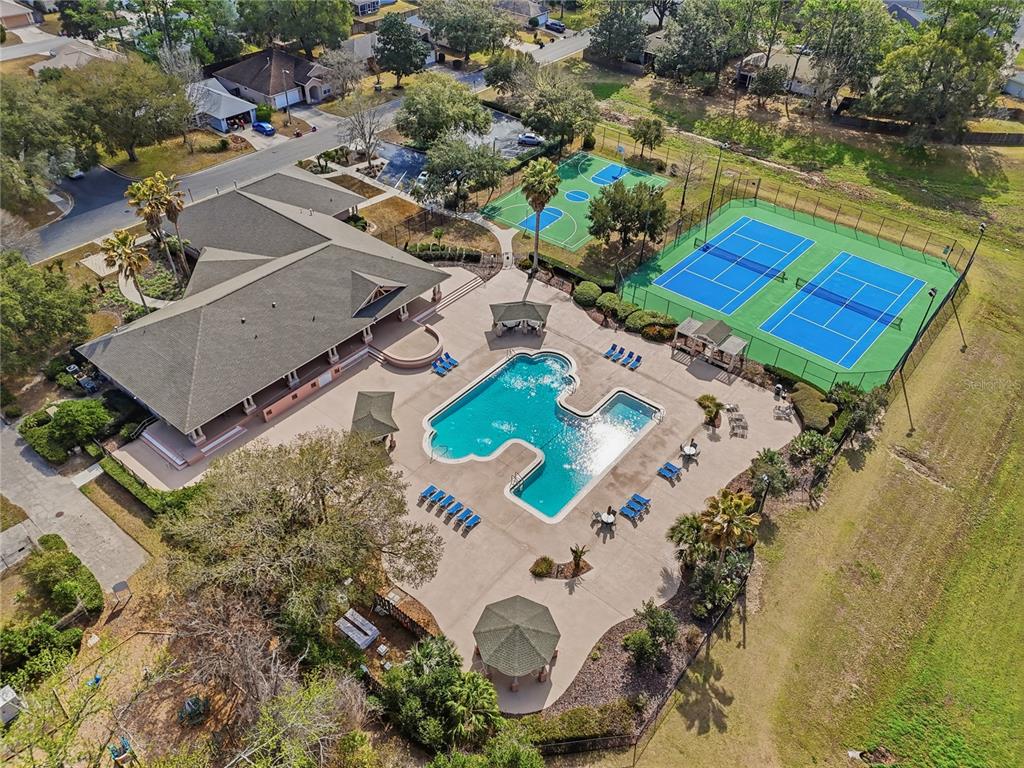 An aerial view shows a community clubhouse with a pool, tennis courts, and basketball court — 4430 NW 35TH TERRACE, GAINESVILLE, FL