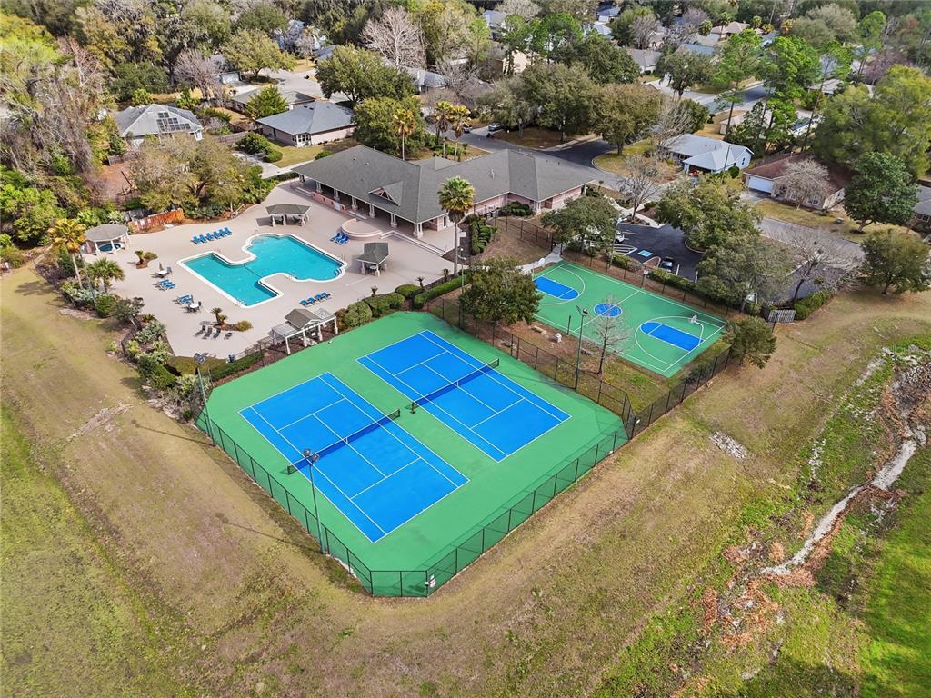 An aerial view shows a community clubhouse with a swimming pool, tennis courts, and basketball court — 4430 NW 35TH TERRACE, GAINESVILLE, FL