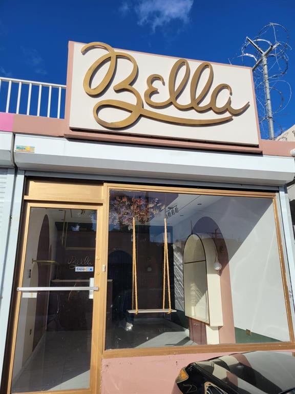 The exterior of a retail storefront features a gold script sign reading Bella above glass — BB 29 AVE SANTA JUANITA, BAYAMON, PR