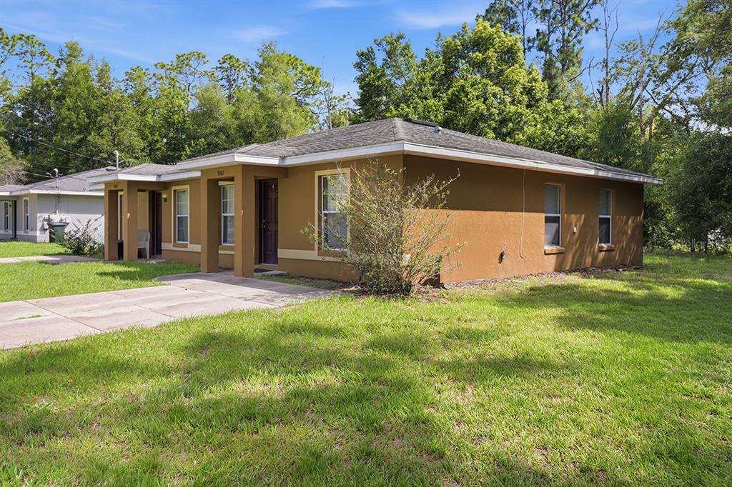 A tan, single-story duplex with a concrete driveway and a grassy front yard — 9261 N PEACHTREE WAY, CITRUS SPRINGS, FL