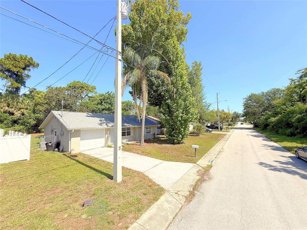 A single-story house with a white garage and a driveway sits along a residential street — 15839 VILLA DRIVE, HUDSON, FL