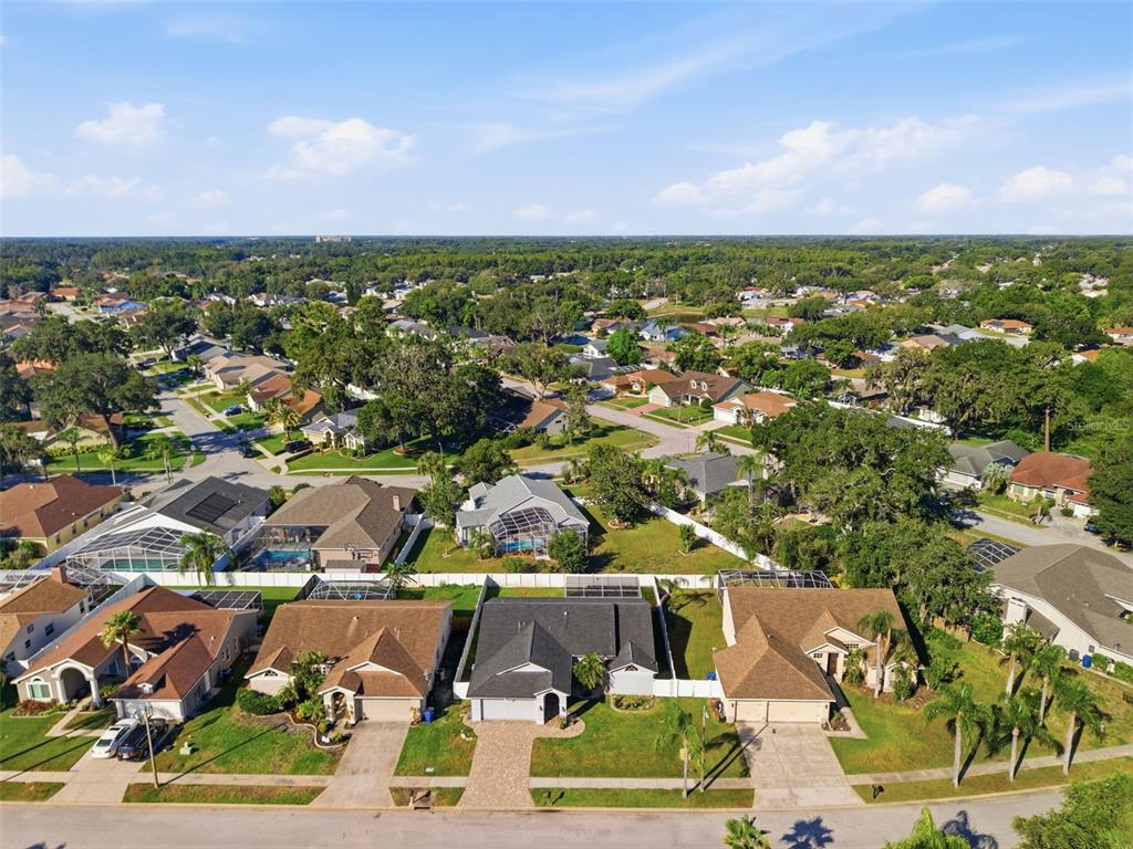 An aerial view of a suburban neighborhood featuring single-family homes with pools and paved driveways — 10050 HERMOSILLO DRIVE, NEW PORT RICHEY, FL
