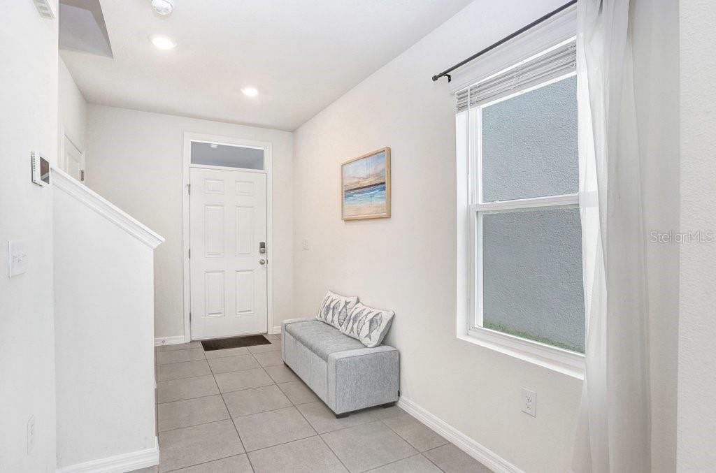 An entryway features tile flooring, a white door, a bench, and a window with blinds — 3044 SUNCOAST PLAINS DRIVE, ODESSA, FL