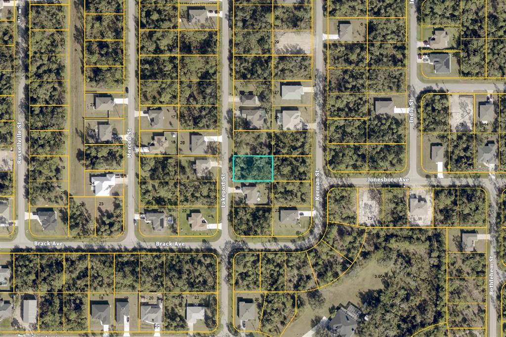 This is an aerial map showing a vacant residential lot highlighted in blue — LAKEPORT STREET, NORTH PORT, FL