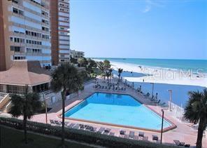 An elevated view of a swimming pool next to a beach and a tall building — 17920 GULF BOULEVARD UNIT 1203, ST PETERSBURG, FL