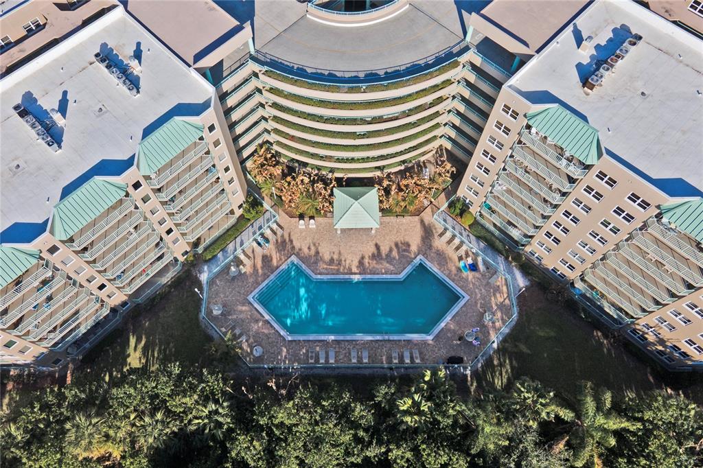 An aerial view shows a multi-story apartment complex surrounding a pool and a small gazebo — 4 OCEANS WEST BOULEVARD UNIT 102C, DAYTONA BEACH, FL