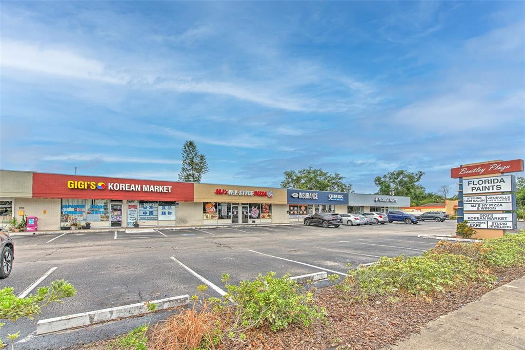 A strip mall features several storefronts, including a Korean market and a pizza shop — 1751 E EDGEWOOD DRIVE, LAKELAND, FL