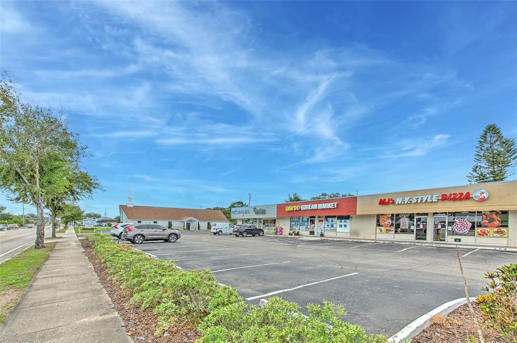 A strip mall with a parking lot, a Korean market, and a pizza restaurant — 1751 E EDGEWOOD DRIVE, LAKELAND, FL