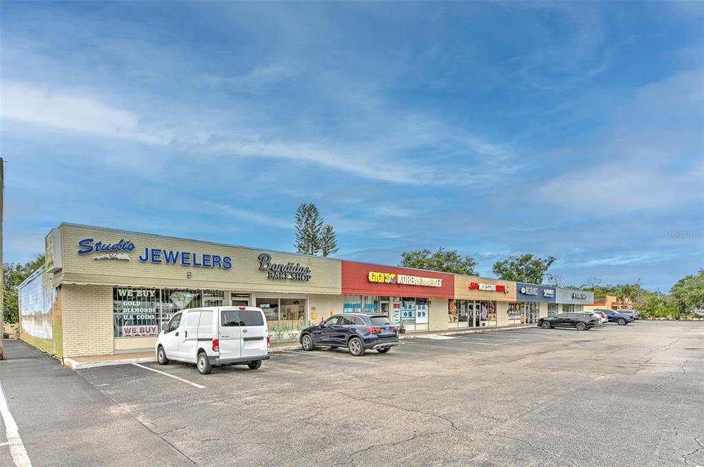 A strip mall features several storefronts, including a jeweler and a Korean market, with parking — 1751 E EDGEWOOD DRIVE, LAKELAND, FL