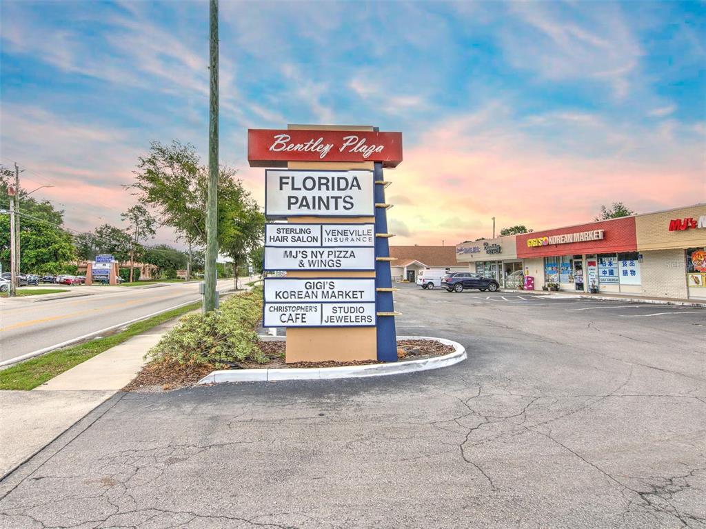 A multi-tenant commercial plaza sign stands in front of a parking lot and retail building — 1751 E EDGEWOOD DRIVE, LAKELAND, FL