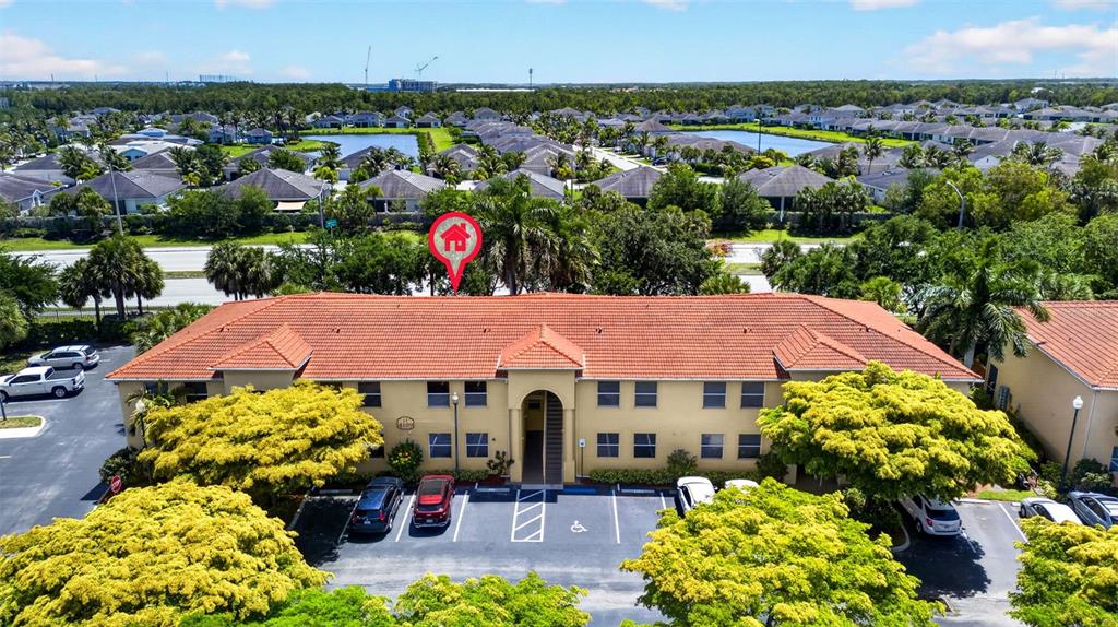An aerial view shows a two-story apartment building with a red tile roof and parking — 4109 BELLASOL CIRCLE UNIT 1113, FORT MYERS, FL