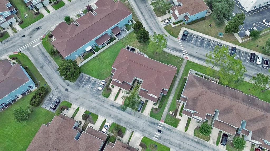 An aerial view shows several multi-story residential buildings with brown roofs and surrounding parking lots — 2016 SCHULLER WAY, CASSELBERRY, FL