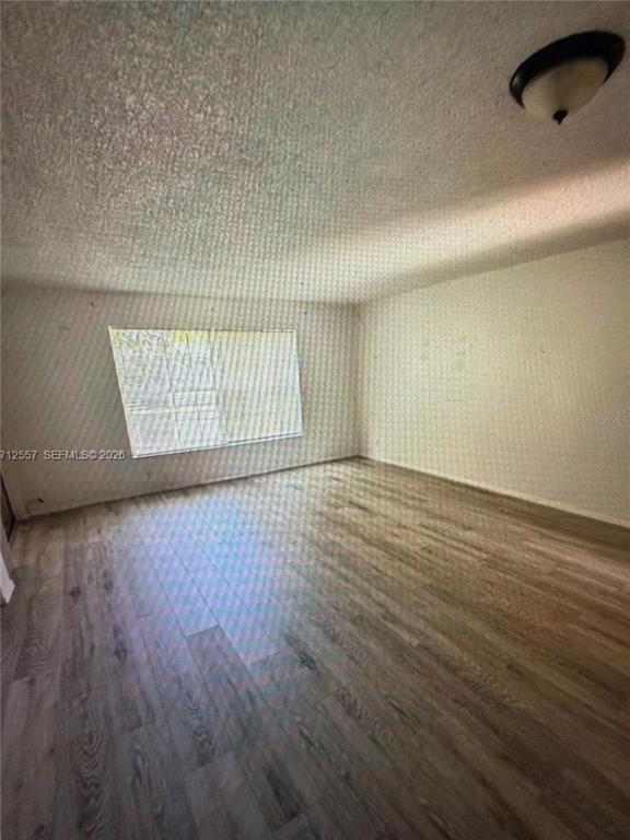An empty room with light wood-look flooring, white walls, a window, and a ceiling light — 4241 NW 19TH STREET UNIT 170, LAUDERHILL, FL