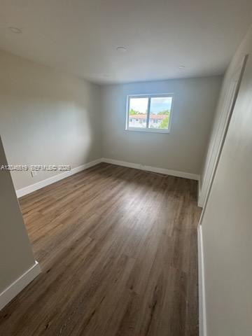 An empty bedroom features light-colored walls, wood-look flooring, recessed lighting, and a single window — 6805 SW 88th St # 5, Pinecrest FL 33156, PINECREST, FL
